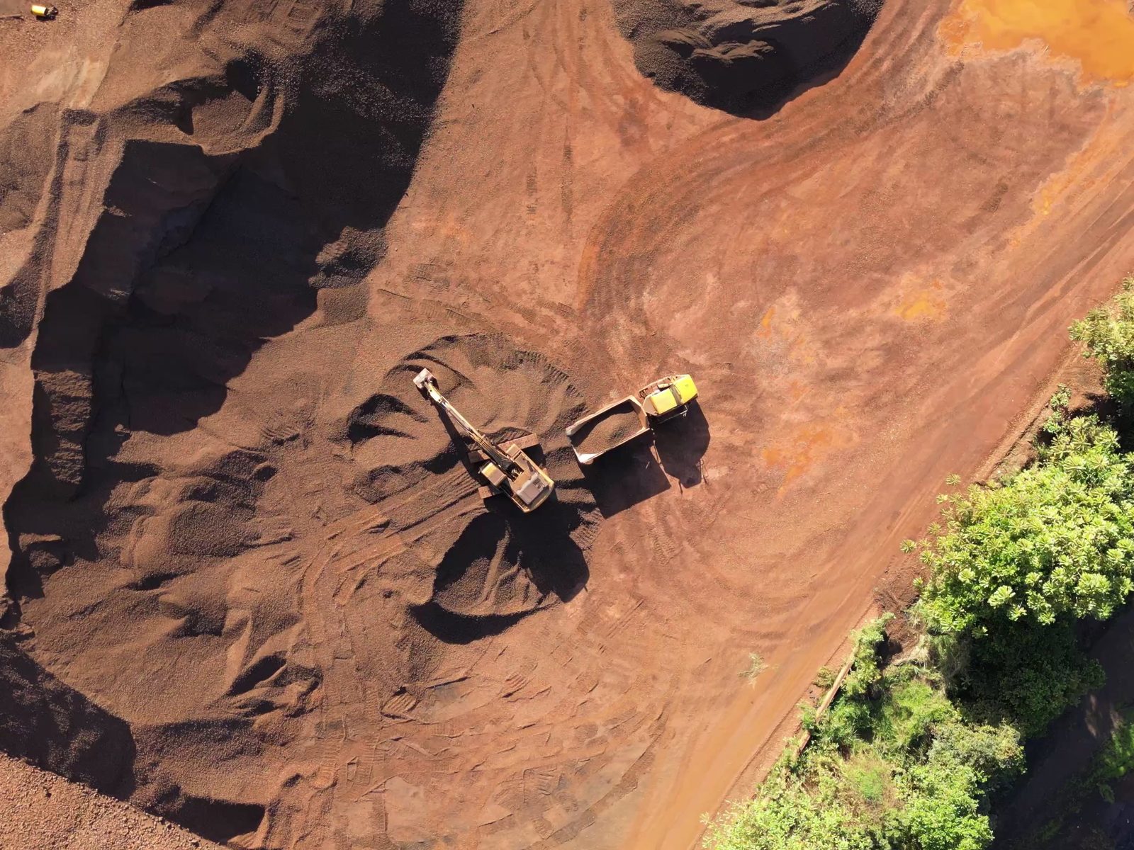 Top-down view of an iron ore stockpile with machinery
