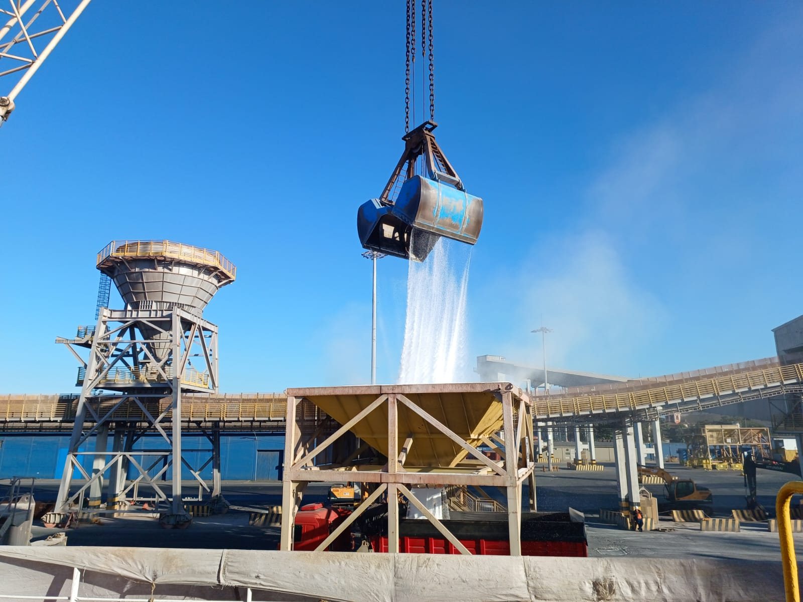 Bulk urea being unloaded by grab into a hopper