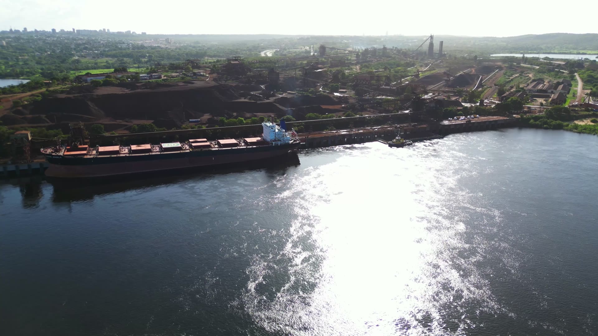 Vista aérea de una operación de carga y transporte fluvial de hierro.
